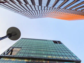 Low angle view of two modern office buildings against hazy sky, Cambridge