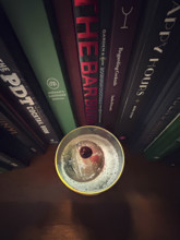 High angle view of whiskey sour cocktail against a row of cocktail recipe books