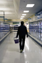 Rear view of mid-adult man shopping for groceries in supermarket