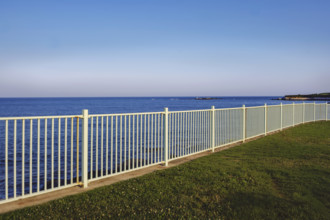 White metal fence along ocean, Newport, Rhode Island, USA