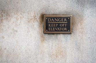 Bronze warning sign mounted on office building