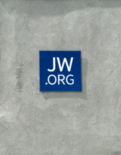 Jehovah's Witness website address on blue tile attached to cement wall