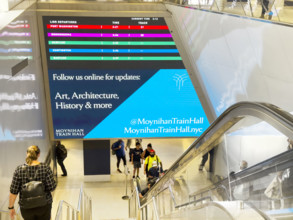 LIRR digital departure board above escalator and stairs, Moynihan Train Hall, Pennsylvania Station,
