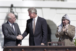 U.S. President Bill Clinton shaking hands with Israeli Prime Minister Yitzhak Rabin as Palestine