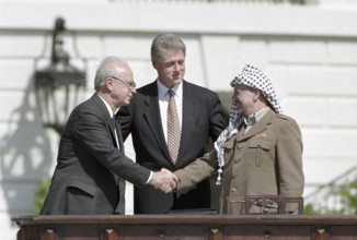 U.S. President Bill Clinton watching handshake between Israeli Prime Minister Yitzhak Rabin and
