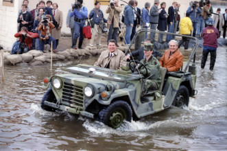 U.S. President Ronald Reagan riding in  military Jeep while touring flood damaged area, Monroe,