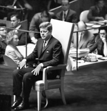 U.S. President John F. Kennedy sitting in chair on platform before General Assembly of the United
