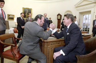 U.S. President Ronald Reagan arm wrestling Dan Lurie of Muscle Training magazine in Oval Office of