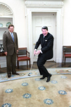 U.S. President Ronald Reagan putting a golf ball with American professional golfer Raymond Floyd