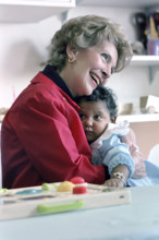 US. First Lady Nancy Reagan holding child while visiting Columbia Presbyterian Medical Center,