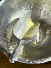 High angle view of metal bowl and scoop used to mix cornbread