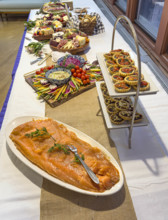 Charcuterie boards, savory tarts and plate of salmon on long table