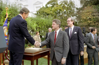 U.S. President Ronald Reagan shaking hands with Arkansas Governor Bill Clinton after signing the