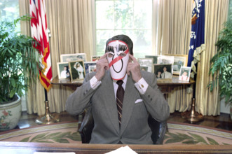 U.S. President Ronald Reagan wearing an anti-Michael Dukakis mask in the White House Oval Office,