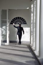 U.S. President Ronald Reagan waving goodbye as he walks along White House Colonnade for the last