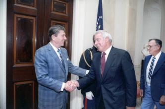 U.S. President Ronald Reagan shaking hands with retired American baseball player Joe DiMaggio at
