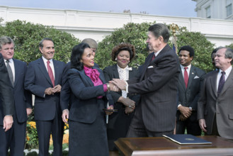 U.S. President Ronald Reagan shaking hands with Coretta Scott King at signing ceremony for HR 3706
