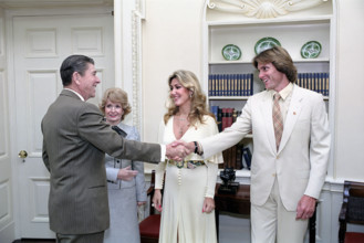 U.S. President Ronald Reagan shaking hands with Bruce Jenner, with his wife Linda Jenner and