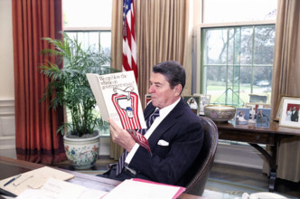 U.S. President Ronald Reagan reading a book "We can blow the whistle on Government waste" in the