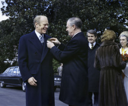 Prime Minister Liam Cosgrave of Ireland pinning shamrocks on U.S. President Gerald R. Ford's lapel