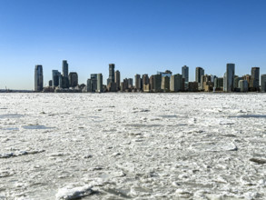 View of Jersey City, New Jersey, USA skyline across frozen Hudson River