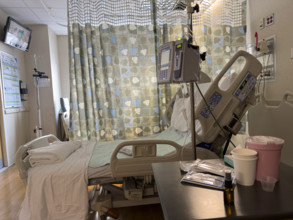 Empty hospital bed in patient room with medical equipment