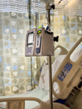 Empty hospital bed in patient room with medical equipment