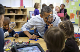 U.S. President Barack Obama playing magnifying glass game with children during a visit to a