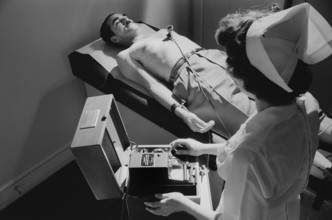 Nurse taking electrocardiogram of male patient, Warren K. Leffler, U.S. News & World Report