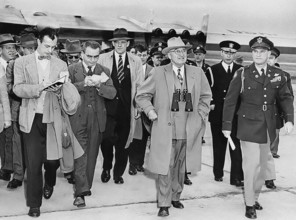U.S. President Harry S. Truman (center, with binoculars) is followed by unknown reporters while
