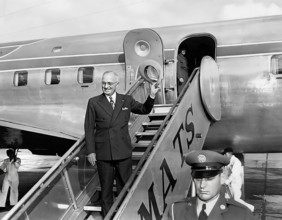 U.S. President Harry S. Truman waving from airplane steps at Washington National Airport prior to