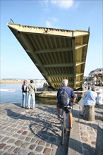 France, Basse Normandie, calvados, cote fleurie, Honfleur, entree et sortie de bateau a l'ouverture du vieux bassin, pont levant, cycliste qui attend, pietons,