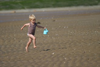 France, Basse Normandie, calvados, cabourg, plage, enfant 3 ans qui court sur le sable, personnage autorise, jeux d'eau, seau, maree basse,