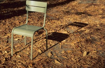 France, Paris 6e, jardin du Luxembourg, chaise vide et son ombre, feuilles mortes dans une allee, Fermob