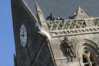 France, Normandie, Manche, plages du debarquement, remplacement du mannequin representant le parachutiste John Steele sur le clocher de l'eglise en memoire du 6 juin 44,