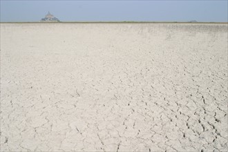 France, Normandie, Manche, baie du Mont-Saint-Michel, sol sec, craquele, maree basse, Mont-Saint-Michel a l'horizon,