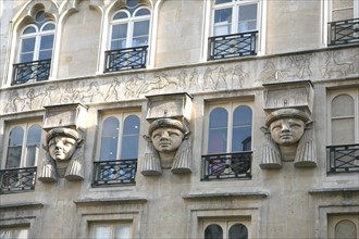 France, Paris 2e, sentier, place du caire, tetes egyptiennes sur la facade de l'immeuble.
