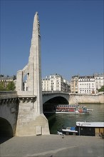 France, Paris 5e, Pont de la Tournelle, Seine, arche, statue, quai de Bethune, Ile Saint Louis, bateau touristique.
Statue de sainte Genevieve sculptee par Paul Landowski en 1928.