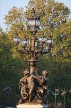 France, Paris 8e/7e arrondissement, pont Alexandre III, detail sculpture bronze, ronde d'amour au pied des candelabres, lampadaires,