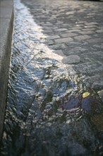 France, Paris 18e, butte Montmartre, place du tertre, eau dans le caniveau, paves, rue,