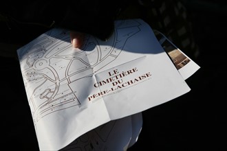 France, Paris 20e, cimetiere du pere Lachaise, personne tenant un plan dans ses mains,