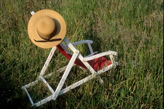 France, Bretagne, Cotes d'Armor, chaise longue avec chapeau de paille dans l'herbe, transat, chilienne, repos, farniente, vacances,