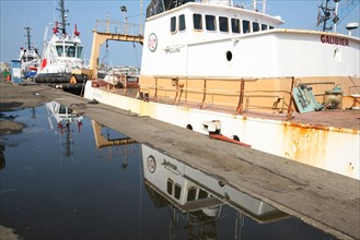 France, Bretagne, Finistere Sud, Cornouaille, Concarneau, port de peche, quai, reflet d'un chalutier dans une flaque d'eau,