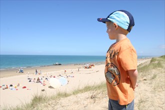 France, Basse Normandie, Manche, saint martin de brehal, plage, sable, enfant 4 ans, regardant la plage et la mer, casquette,
