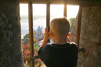 France, Basse Normandie, Manche, pays de la baie du Mont-Saint-Michel, 
enfant regardant le couesnon au travers de grilles, personnage ok,