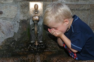 France, Basse Normandie, Manche, pays de la baie du Mont-Saint-Michel, enfant de 6 ans buvant de l'eau a une fontaine, personnage ok,