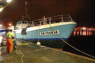 France, Basse Normandie, Manche, Cotentin, Cherbourg, bassin du commerce, centre de maree, debarque de nuit d'un chalutier a quai, lumieres de la ville,