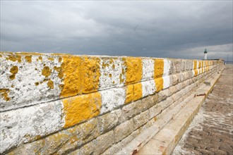 France, Bretagne, Morbihan, ile de groix, port tudy, digue, peinture jaune et blanche, phare, ciel menacant,