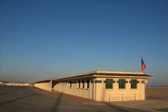 France, Basse Normandie, Calvados, Deauville, front de mer, colonnes, etablissement des bains de mer, cabines, ombres et lumieres, plage et parking vides, petit matin,