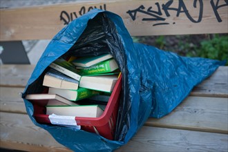 Allemagne (Germany), Berlin, Prenzlauer Berg, Oderberger Strasse, sac de livres deposes sur un banc,